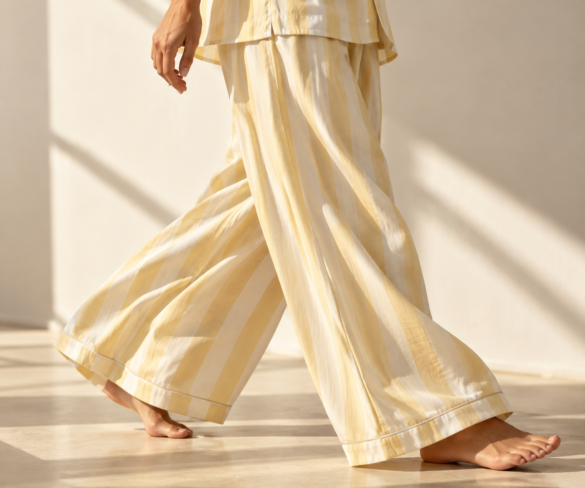 Buttery-yellow and ivory striped trousers moving in warm sunlight